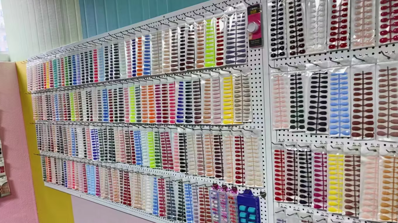 Pared de exhibición de la fábrica MIFFANS con cientos de juegos terminados de uñas postizas