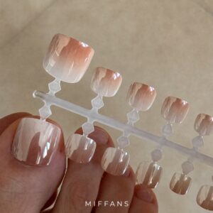 Puntas de uñas postizas metalizadas efecto aurora para pies sobre soporte